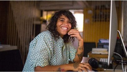 Portrait of a person smiling, using a computer.