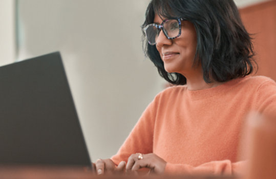 Eine Frau, die mit ihrem Laptop arbeitet.