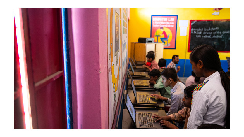 Barn som jobber på datamaskiner i et klasserom.