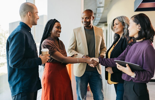 A group of people shaking hands in a friendly meeting.
