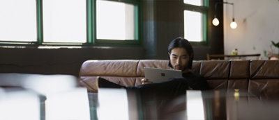 A man sitting on a couch using a laptop