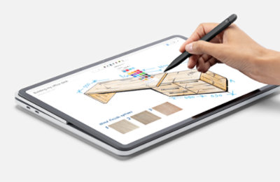 An image of a hand with a digital pen sketching a table on a tablet.