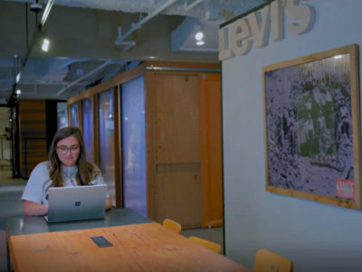 A women working on a laptop in a modern office.