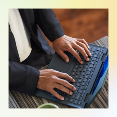 Professionnel travaillant sur un ordinateur portable sur un bureau en bois.