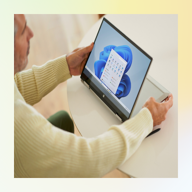 画面上に予定表を表示しているノート PC を使用している年配の男性。