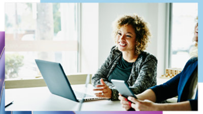 People collaborating with a laptop and mobile device in an office.