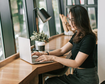 一個女孩坐在桌前使用電腦