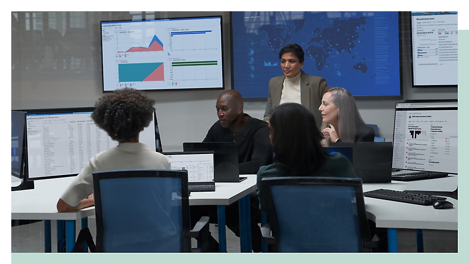 Group of people discussing in an office room with presentation being displayed on the monitor