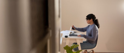 A person sitting at a desk with a book and a computer