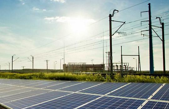 Solar panels in the grass under powerlines