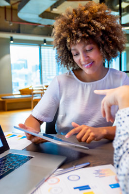 Mujer en la oficina trabajando en su tableta y hablando