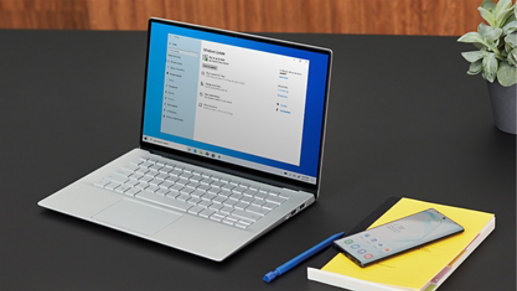 Una computadora portátil con una pantalla de actualizaciones de Windows se encuentra sobre una mesa.