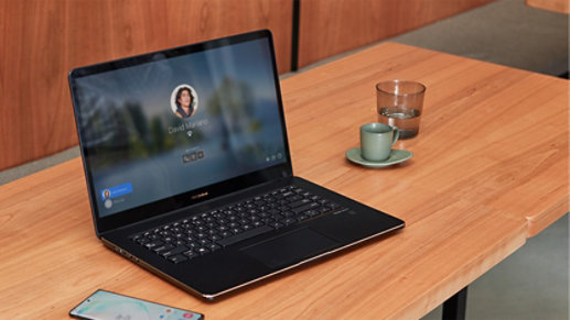 A laptop with a Windows Hello screen sits on a desk.