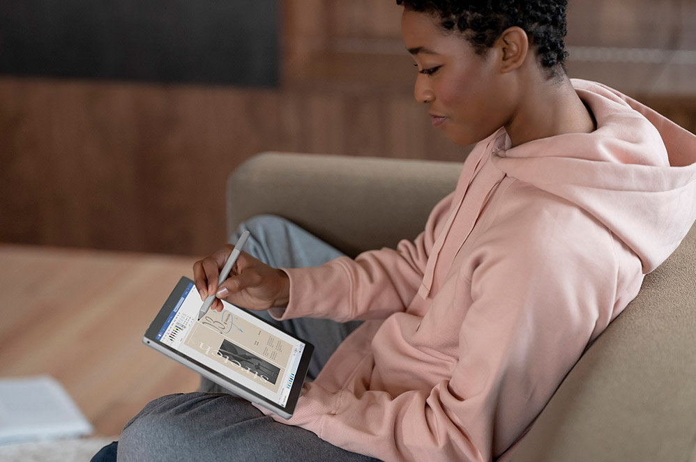 Una mujer usa Surface Pro 7+ como tableta con el Lápiz para Surface.