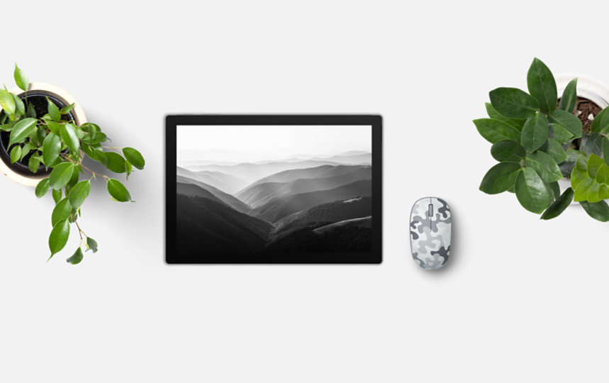 Microsoft Bluetooth Mouse Camo Special Edition bredvid en surfplatta sedda ovanifrån.