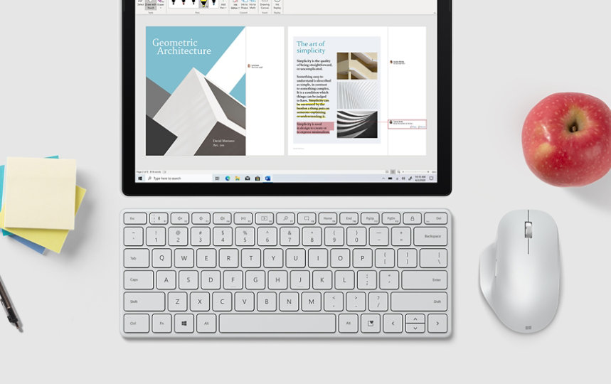 Microsoft Designer Compact Keyboard przed tabletem obok myszy Microsoft, kartek i pióra.