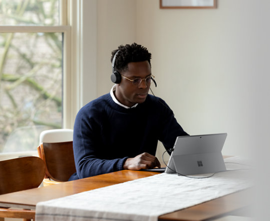Person wearing Microsoft Modern USB headset while using a laptop.