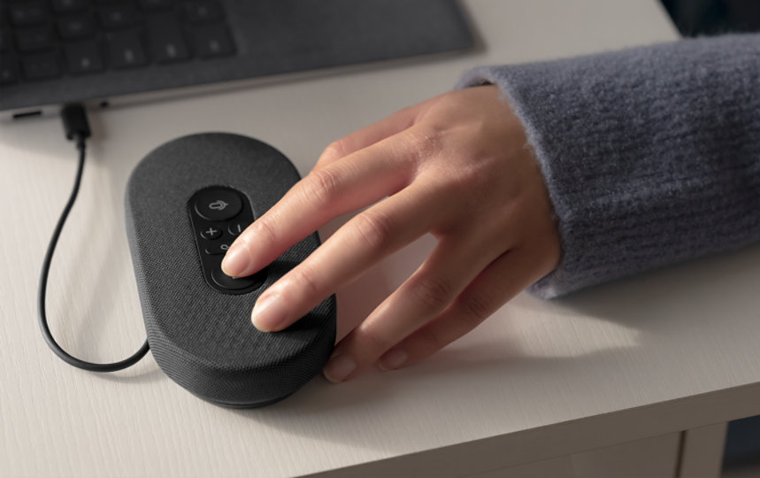 A person's hand on an Microsoft Modern USB-C Speaker.