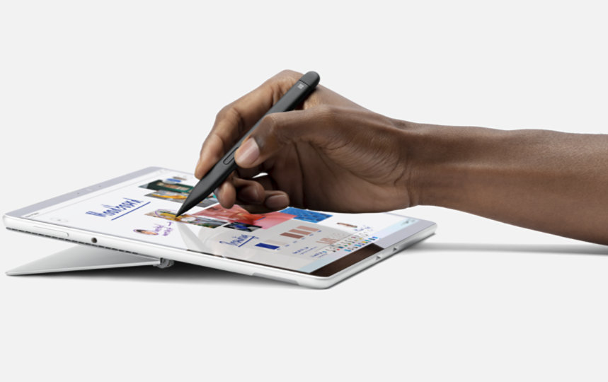 A hand writing with a Surface Slim Pen on a Surface device in tablet position.