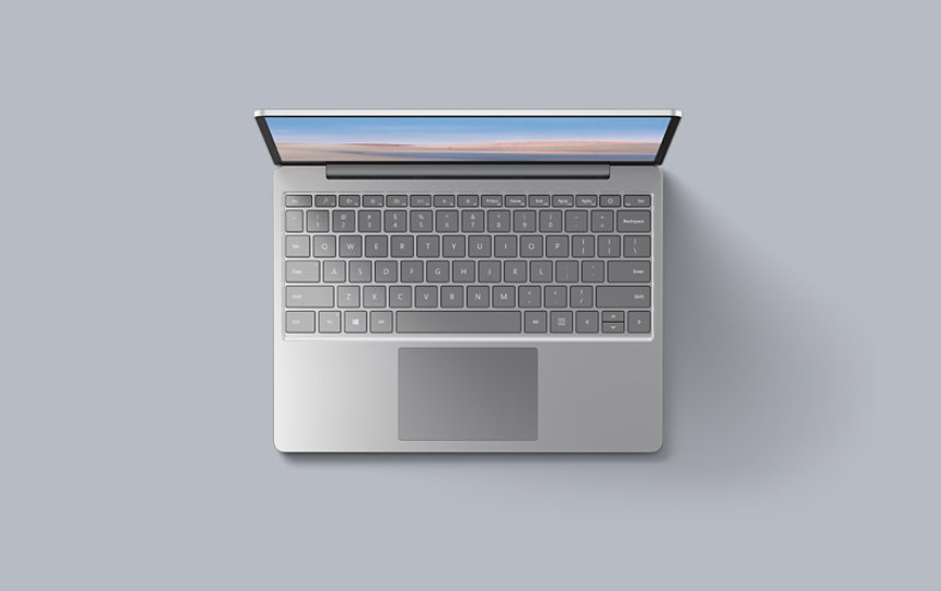 An aerial view of the platinum Surface Laptop Go resting upon a matching background.