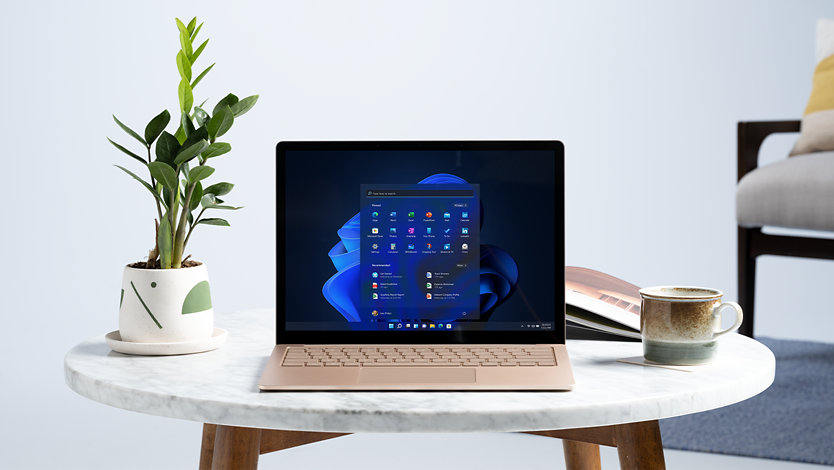 A Surface Laptop with Windows 11 and other icons.