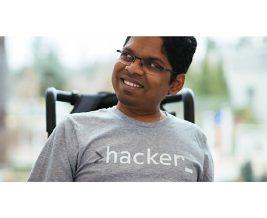 A smiling man sitting in a wheelchair.