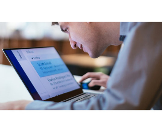 A man working on his Windows 10 computer with easy-to-read large  text on screen.