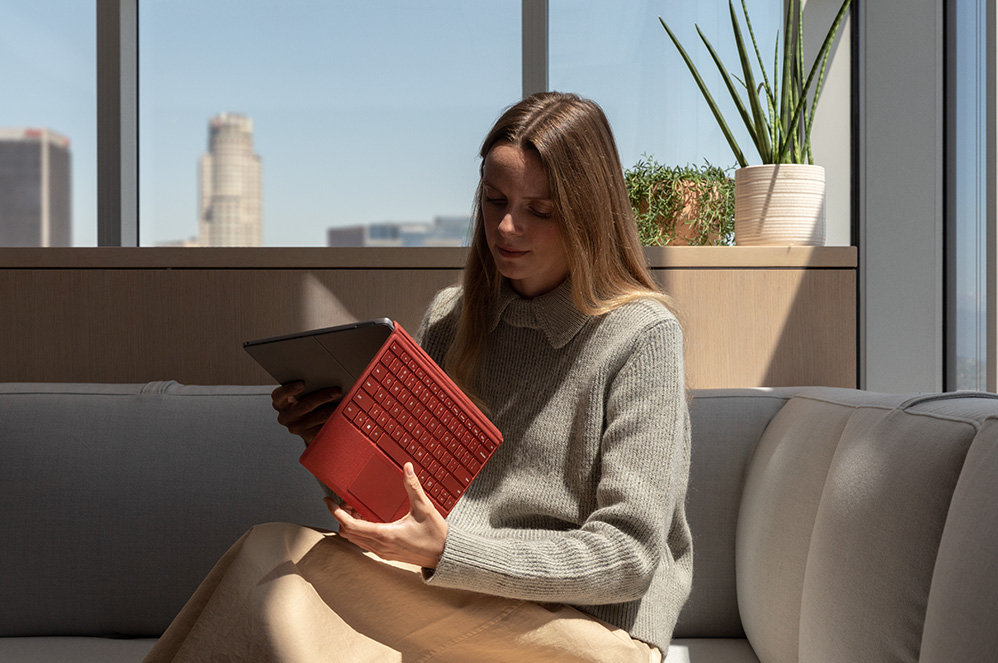 Eine Person entspannt zu Hause und benutzt das Surface Pro 7 mit Type Cover.