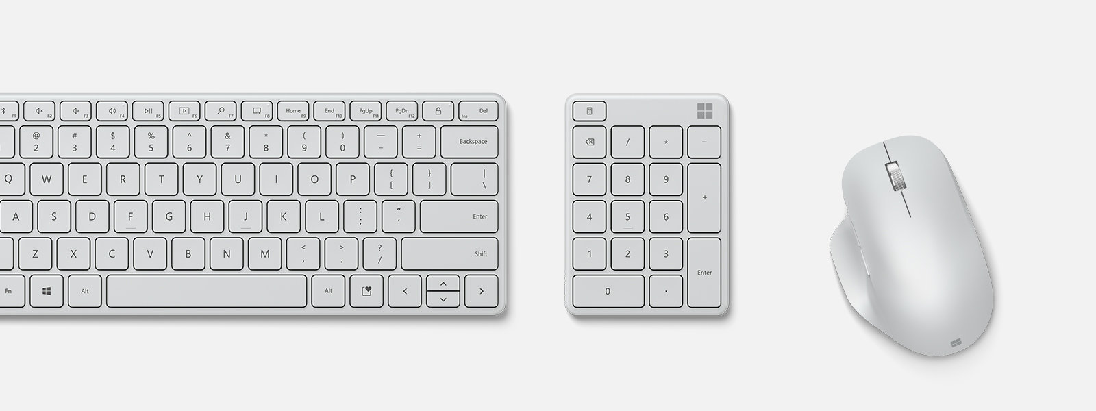 En Microsoft Number Pad i grått mellan ett tangentbord och en mus. 