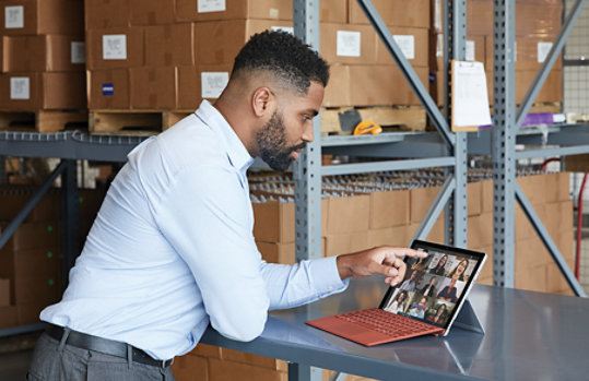 A person standing at a desk working with Surface Pro 7 plus for Business.