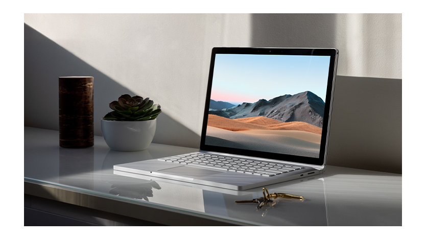 Surface Book 3 para empresas sobre una mesa y con un lápiz, mostrando la pantalla y el teclado