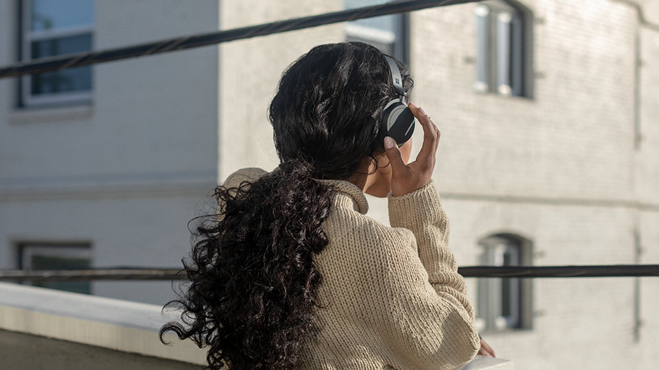 Person standing outside wearing Surface Headphones+.