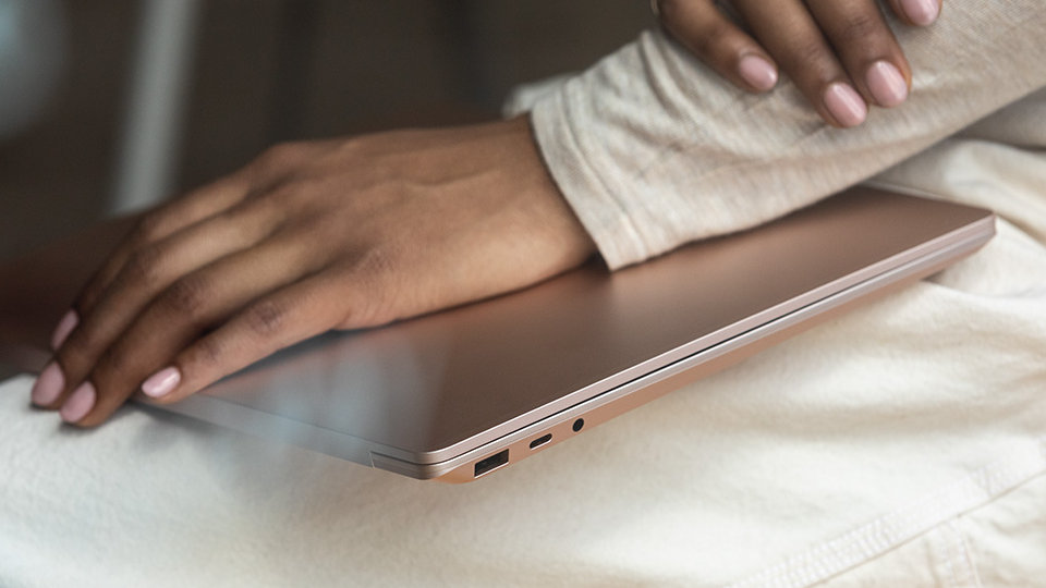 A woman's hand resting on top of Surface Laptop 3.