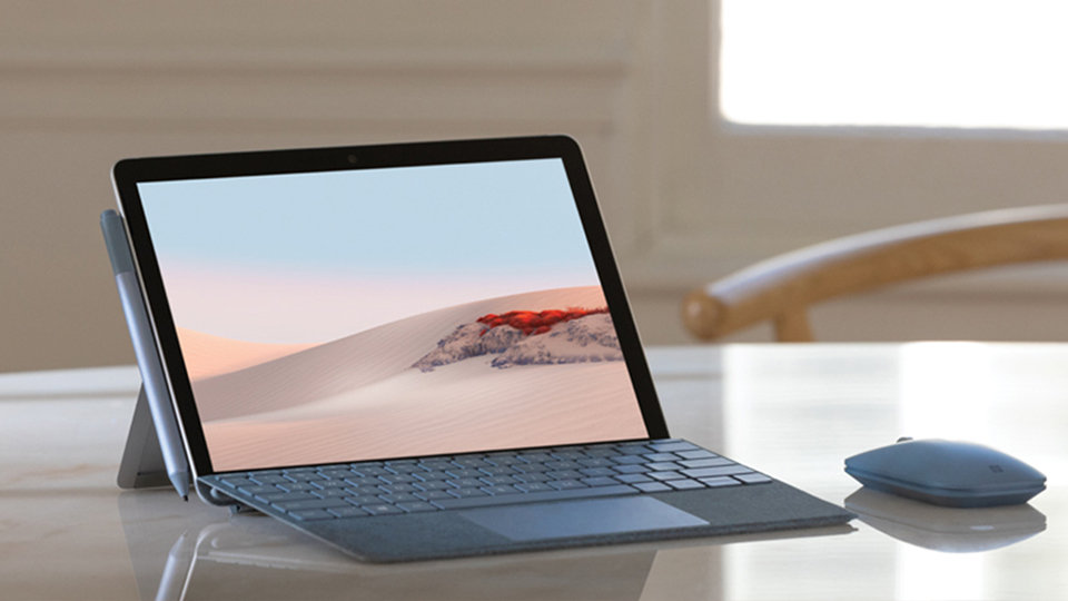 En Surface Mobile Mouse, en Surface-enhet och en Surface-penna på ett bord.