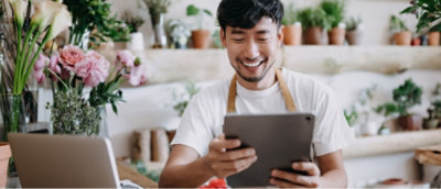 A person is using a tablet and smiling. 