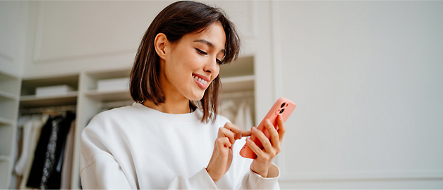 A person is using a mobile and smiling.