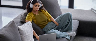 A girl wearing headphone and working on laptop.
