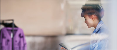 A girl wearing a blue shirt and using a tablet.