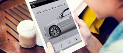 Een vrouw die een iPad gebruikt om naar een auto te kijken.