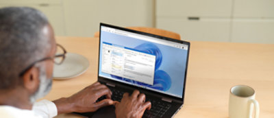 صورة لرجل يعمل مع جهاز كمبيوتر محمول.