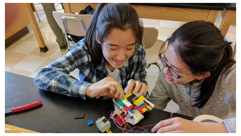 Two young girls work on a project together.
