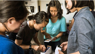 A group of girls work together on a project.