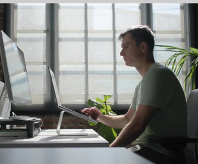 A person sitting in front of a computer screen.