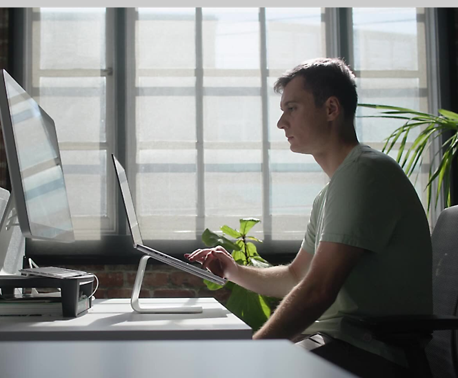 Uma pessoa sentada em frente a um ecrã de computador.