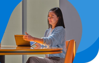 Человек работает на планшете, сидя за круглым столом.