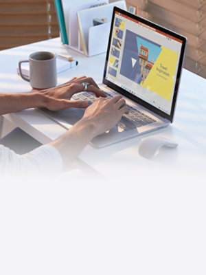Ein Mann, der an einem professionellen Arbeitsplatz auf einem Surface Laptop mit PowerPoint arbeitet. 