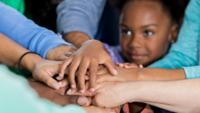 Children and adults stacking hands