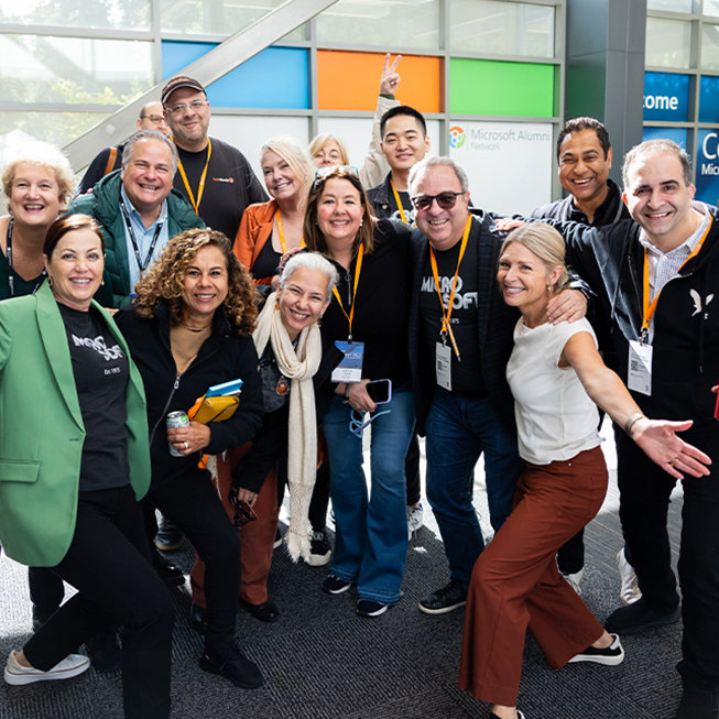 A group of Microsoft Alumni standing together smiling.