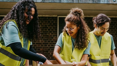 Smiling male and female volunteers working at table for a non-profit organization.