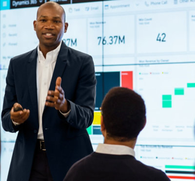 A person in a suit giving a presentation to a group of people